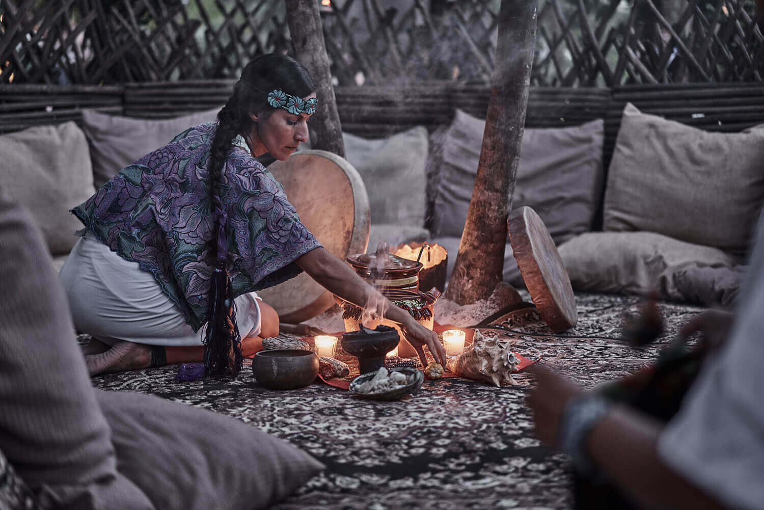 woman preparing bonfire for the spiritual session with nature at nomade Tulum