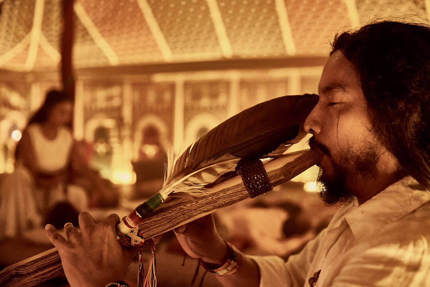 person playing flute for guests at nomade Tulum