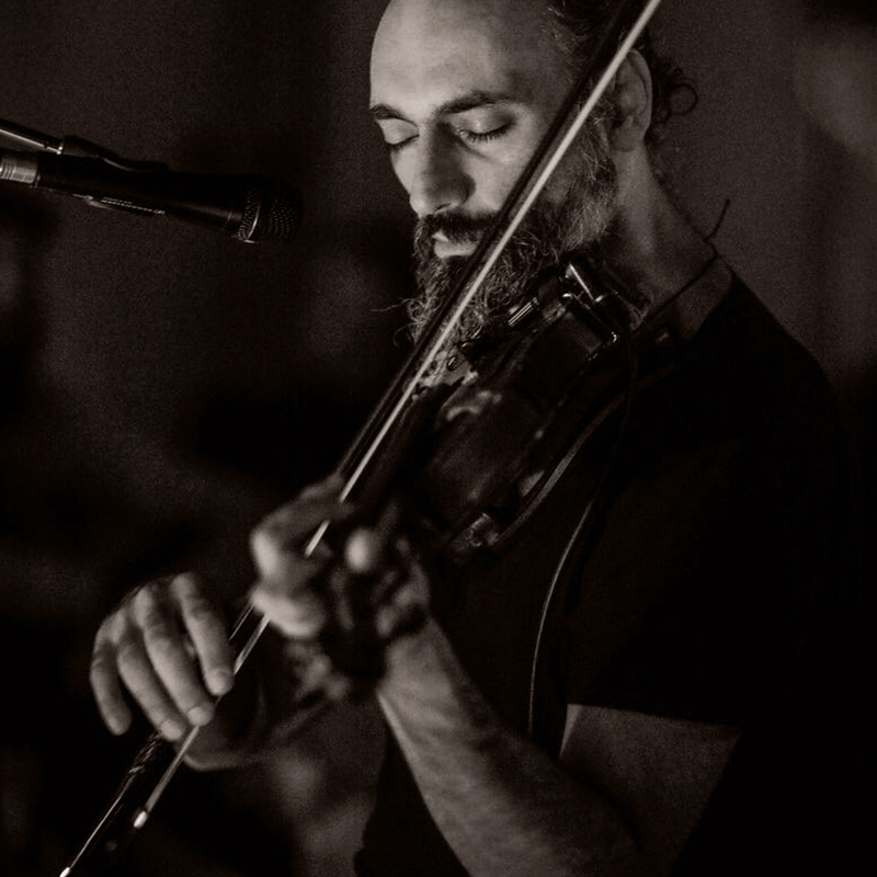 Bodgan playing violin as live perform at nomade Tulum